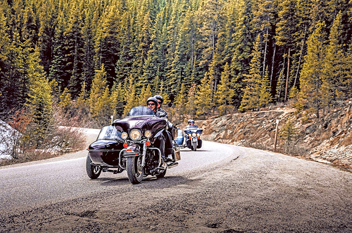People riding on motorbikes through Jasper National Park, Canada