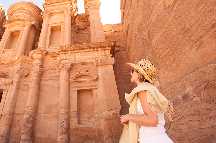 A woman looking at the ancient buildings in Petra, Jordan