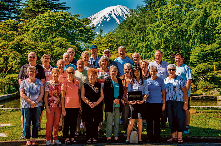Group of guests standing in front of Mount Fuji Japan 