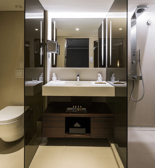   A stylish bathroom in a Deluxe Suite on the Scenic Spirit ship, with a modern toilet, vanity, and shower.