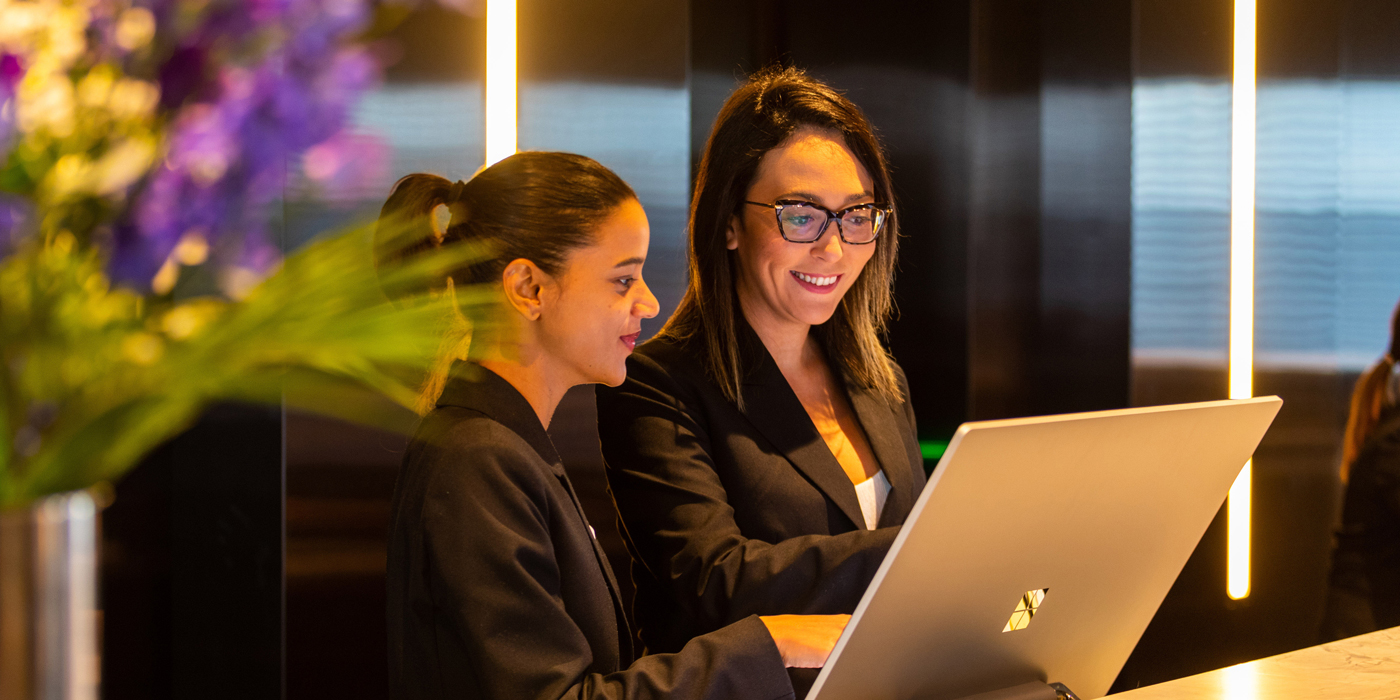 Two women at reception computer