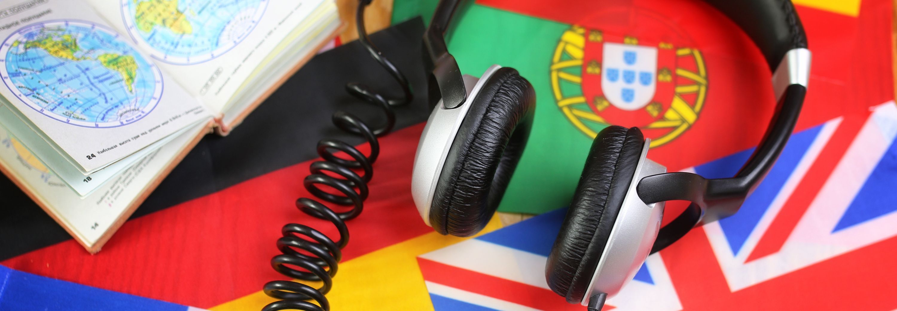 Language course headphone and flag on wooden table