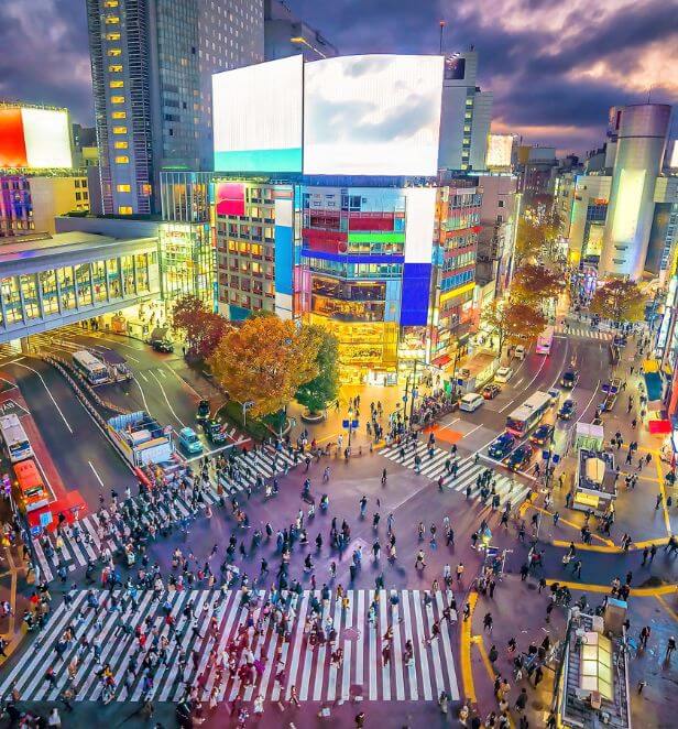 Shibuya Crossing in Tokyo filled with people under bright city lights