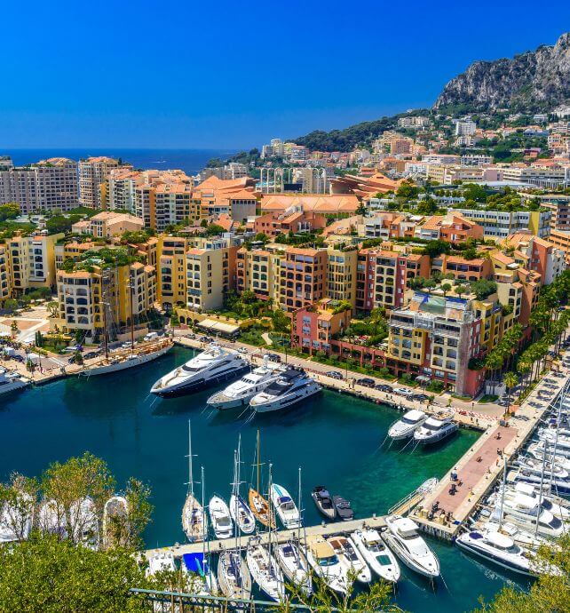 Marina filled with yachts surrounded by colorful buildings in Monte Carlo