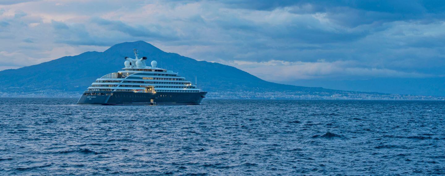 Scenic Eclipse yacht sailing near the coast of Sorrento, Italy, with mountains in the background