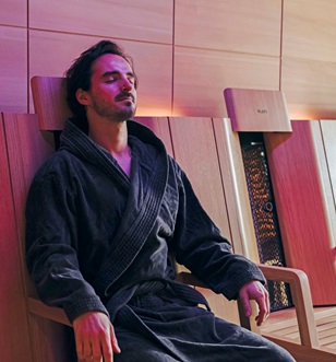 Man relaxing in ambient lit spa room